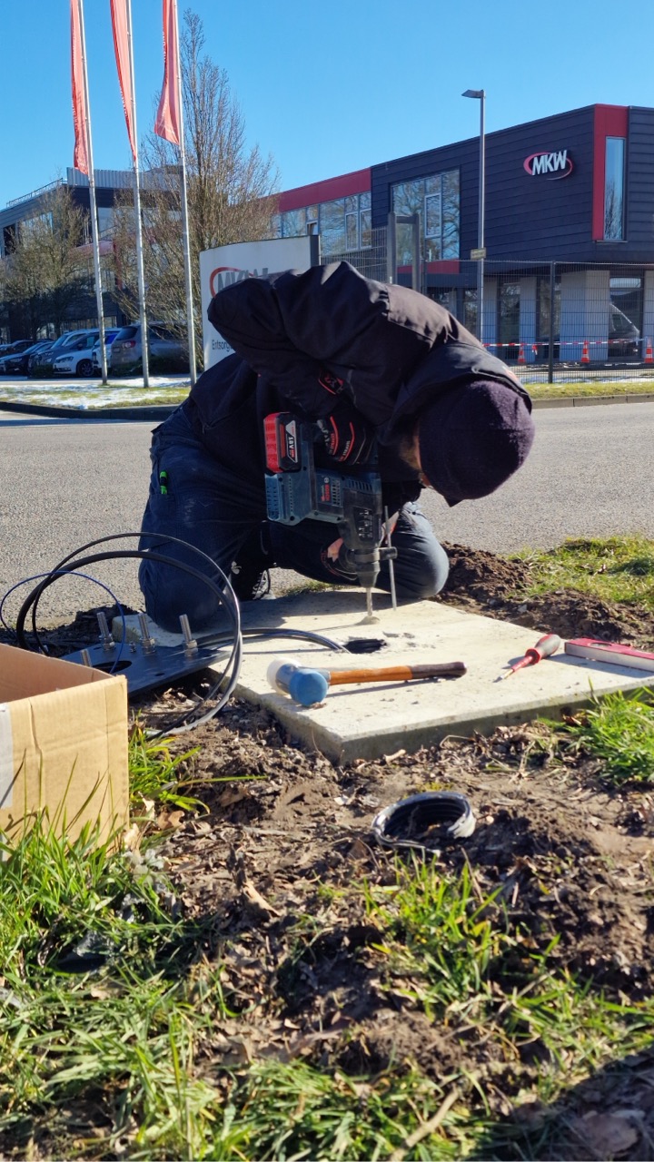 Mitarbeiter von LS IT & MEDIA bohrt vor dem MKW-Gebäude in den Boden