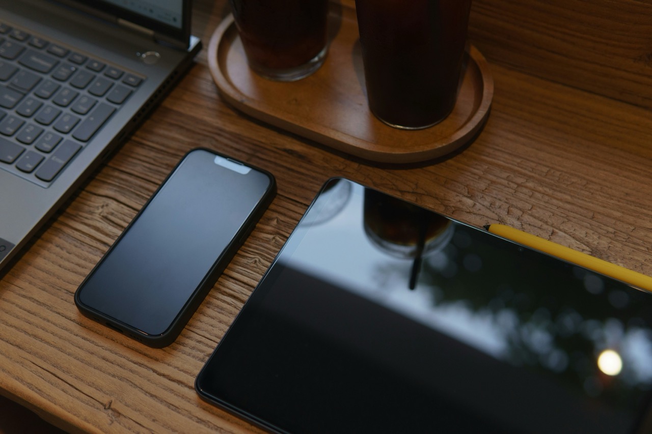 Verschiedene Geräte wie ein Laptop, Smartphone und Tablet auf einem Tisch